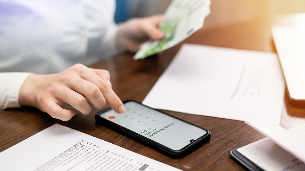 Image of an installment loan repayment plan being calculated with cash and a calculator